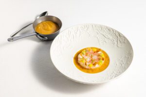Fijn opgemaakt gerecht met garnituur op een wit bord