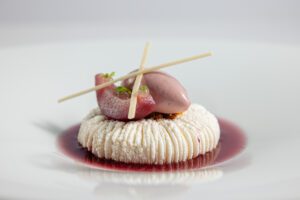 Gerecht met vis en saus op een donker bord